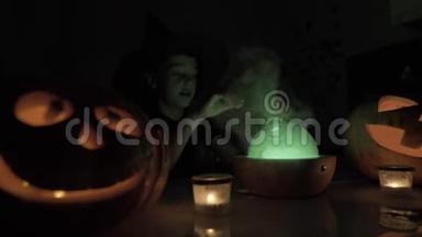 万圣节9岁男孩扮演巫师。 晚上桌子上有一盏神奇的灯和一个南瓜。